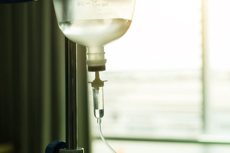 Saline IV drip for patient and Infusion pump in hospital, In the hospital with a fragment of medical equipment.の写真素材