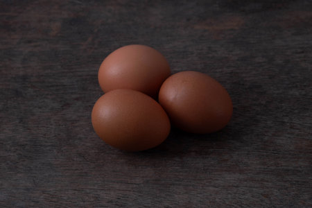 Fresh eggs on a brown table.