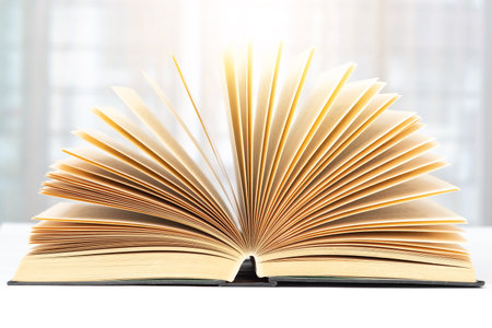 Open book side view on white tabletop and blurred background.の写真素材