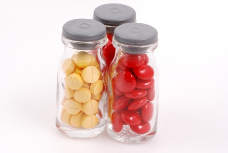 Pills in Glass Bottles on White Background