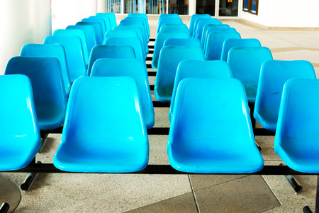 Row of Empty blue plastic chairs  Empty blue seatの写真素材