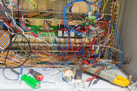 The wires connected to the device inside the Untidy cable Electrical cabinet