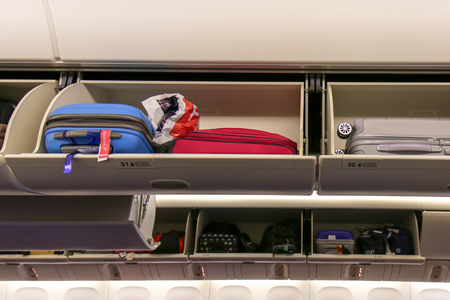 Open luggage rack Economy class cabin in a modern civil airplane.の写真素材