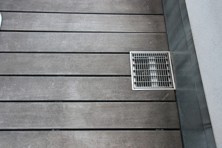 The Old Grate of Drain cover on street woodの写真素材