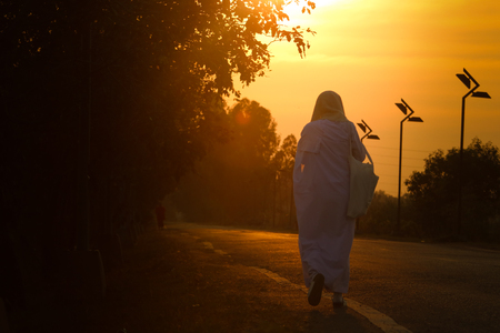 nun walking on the city street with sunset backgroundの写真素材