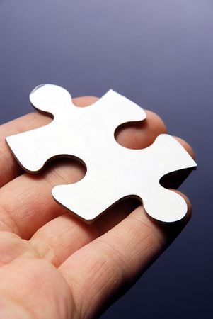 Hand holding a puzzle piece high resolution image