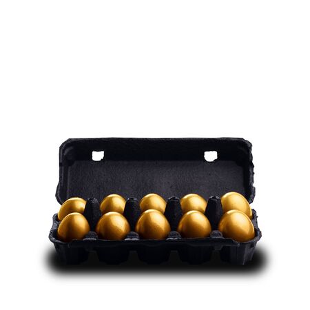 Gold eggs in a black carton isolated on white backgroundの写真素材