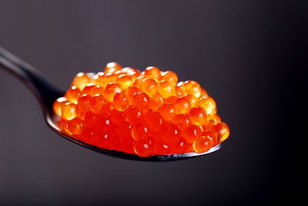 Red caviar in spoon on dark backgroundの写真素材
