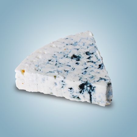 danish blue cheese on a blue backgroundの写真素材