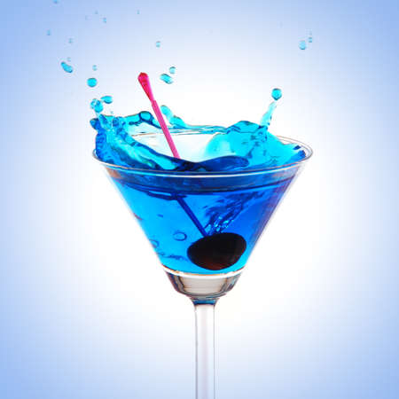 blue cocktail splashing on white backgroundの写真素材