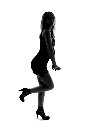 stylish silhouette of caucasian woman posing, studio shot, isolated on white background の写真素材