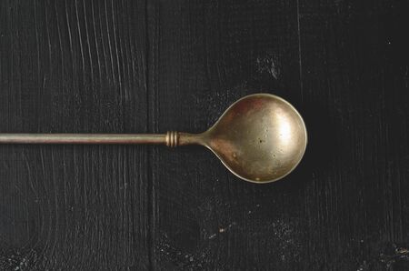 Old metal spoon on dark background with copy spaceの写真素材