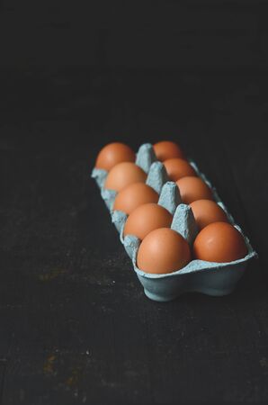 Chicken eggs on a dark wooden table