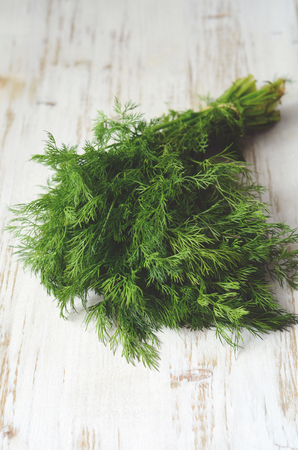 bunch of fresh organic dill on a rustic wooden backgroundの写真素材