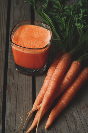 Fresh squeezed carrot juice on wooden backgroundの写真素材