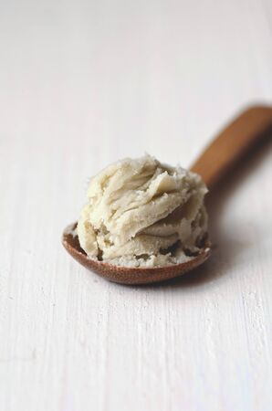 Unrefined raw shea butter on wooden background