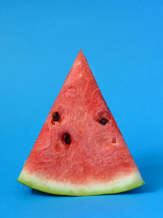 Slice of ripe watermelon on a blue backgroundの写真素材