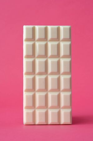 bar of white chocolate on pink background