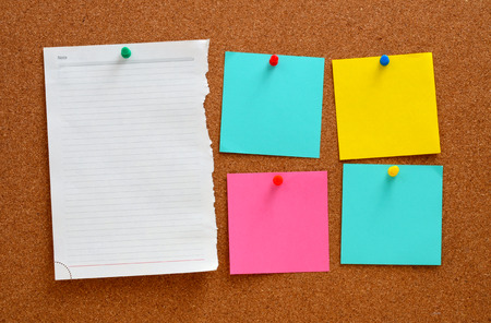 Blank, colourful notes pinned into brown corkboardの写真素材