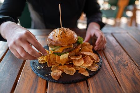 Home made cheeseburger, served with home made potato chipsの写真素材