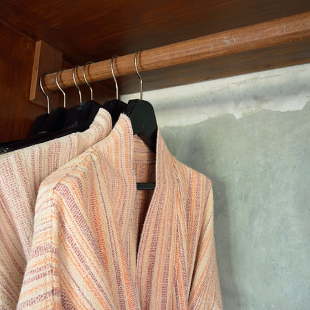 clothes hanger and bathrobe in wardrobeの写真素材