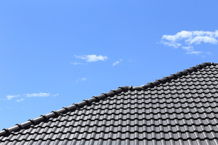 black tiles roof on a new house with blue skyの写真素材