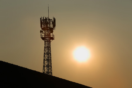 Antenna of radio communication and satellite tower silhouette silhouette with sunset backgroundの写真素材