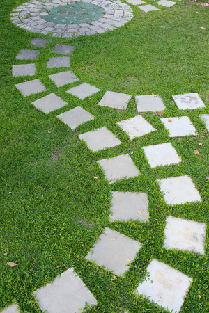 cement stone pathway in green grass gardenの写真素材