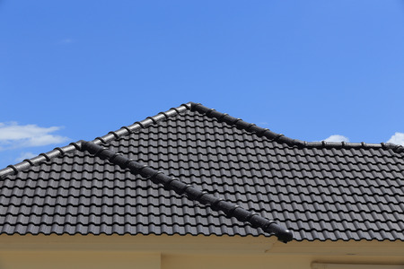 black tiles roof on a new house with blue skyの写真素材