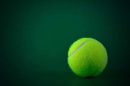 Single tennis ball on green backgroundの写真素材