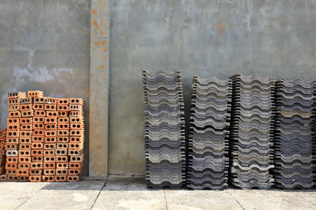 Stack roofing tiles and red brick for building constructionの写真素材