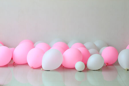 pink and white balloon on floor with white wall backgroundの写真素材
