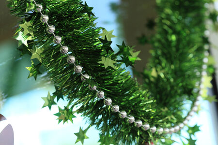 new year festive decoration with green tinsel ribbon and silver beadの写真素材