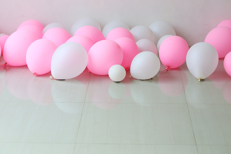 pink and white balloon on floor with white wall backgroundの写真素材