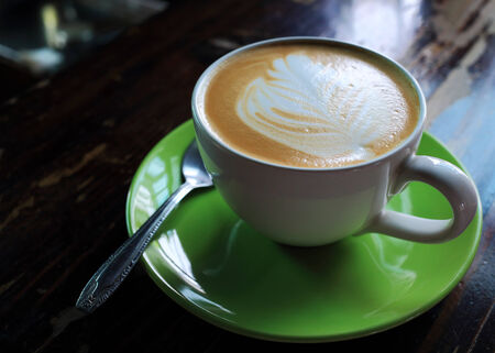 coffee espresso, white coffee cup and green saucer on wooden tableの写真素材