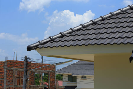 black tile roof on a new house with blue skyの写真素材