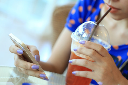 woman using a smart phone in cafeの写真素材