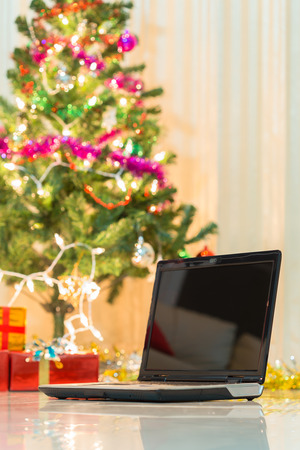 laptop with gift box and christmas lights backgroundの写真素材
