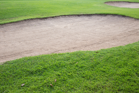sand bunker and green grass of golf courseの写真素材