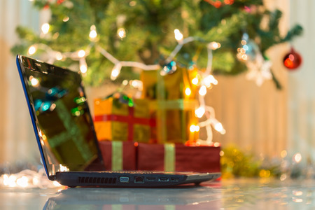 laptop with gift box and christmas lights backgroundの写真素材