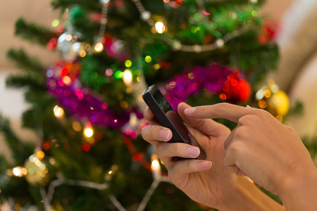 hand using mobile smart phone with colorful light celebration backgroundの写真素材