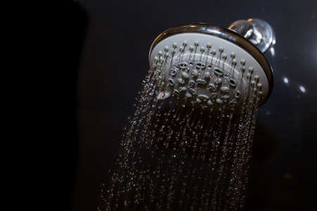 shower head in bathroom with water drops flowingの写真素材