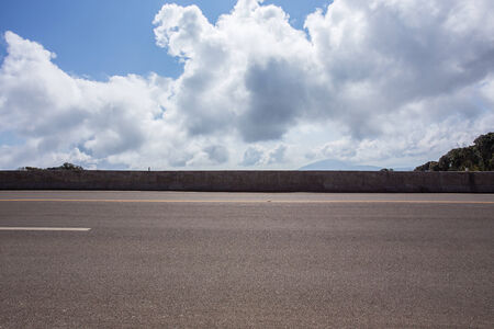 asphalt roadway with cloud blue sky backgroundの写真素材