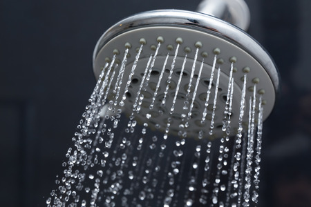 shower head in bathroom with water drops flowingの写真素材