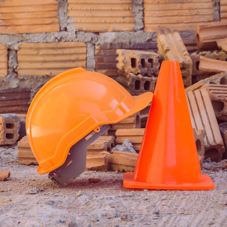 construction helmet safety and cone in construction site with bricksの写真素材