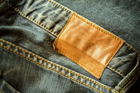 brown leather tag on black jeansの写真素材
