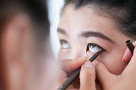 makeup beauty with brush eye liner on pretty woman faceの写真素材