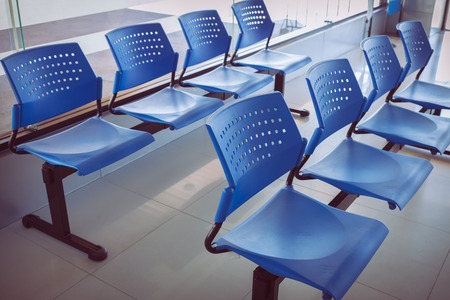 customer waiting area with rows of blue seats in officeの写真素材