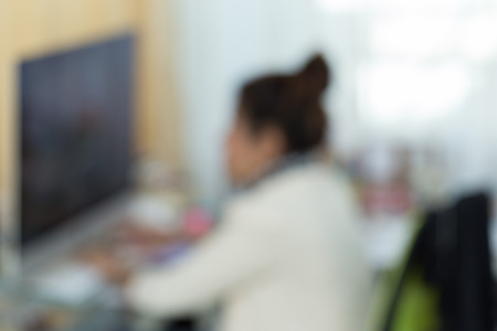 working woman with computer, image blur backgroundの写真素材