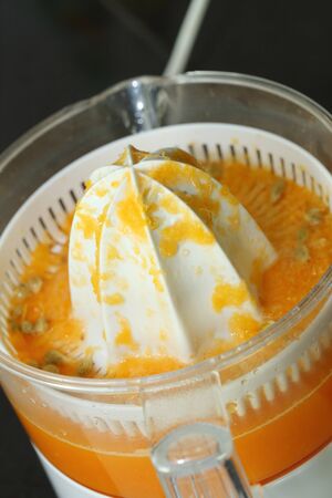 juicer machine with hand, fresh orange juiceの写真素材